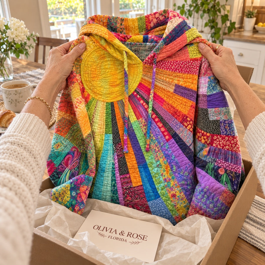 Hands holding up the Amanda hoodie above its Olivia & Rose box