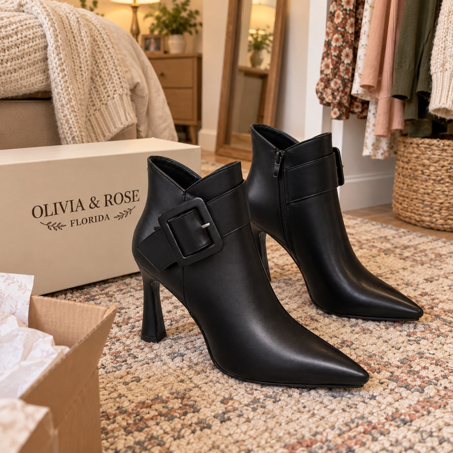 The black Raina boots next to their box, showing the side zipper
